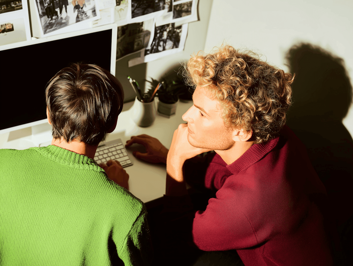 Two colleagues reviewing work at a desk in warm light